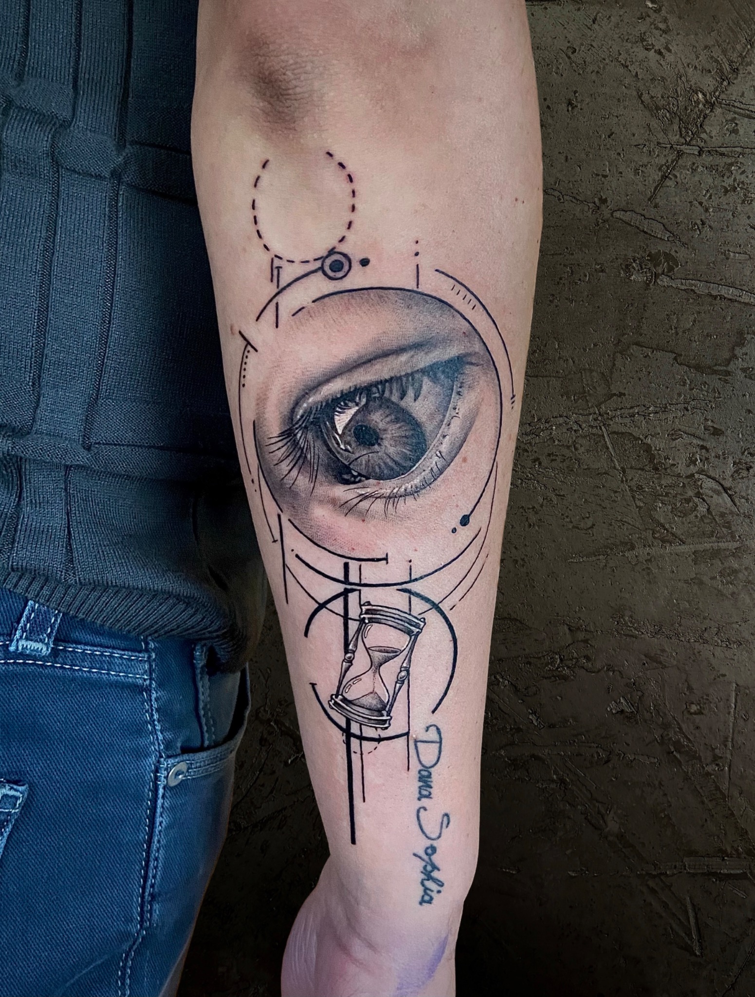 Realistisches Auge mit Sanduhr und geometrischen Linien auf dem Unterarm